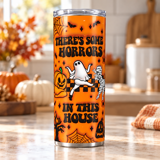 Theres Some Horrors in This House on orange — one 20 oz skinny stainless steel tumbler in a kitchen lifestyle mockup