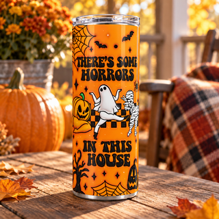 Theres Some Horrors in This House on orange — one 20 oz skinny stainless steel tumbler on an autumn porch lifestyle mockup